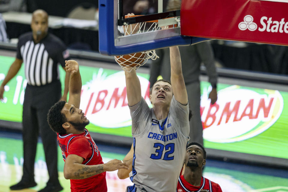 Creighton center Ryan Kalkbrenner (32) makes a dunk against St. John's guard Julian Champagnie (2) in the first half during an NCAA college basketball game, Saturday, Jan. 9, 2021, in Omaha, Neb. (AP Photo/John Peterson)