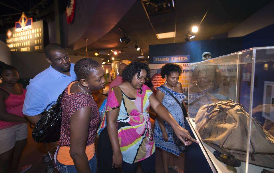 FILE - Jimmie Reid, left, Tabitha Reid, second from left, Melissa Reid, and Wanda Taylor, right, all visiting from states across the country for a family reunion, visit the Negro Leagues Baseball Museum in Kansas City, Mo., July 3, 2012. The Negro Leagues Baseball Museum is embarking on a fundraising campaign to raise $25 million for a new building in Kansas City, Missouri, to house its education center and what has become one of the world's unique collections of baseball memorabilia. (AP Photo/The Kansas City Star, David Eulitt, File)