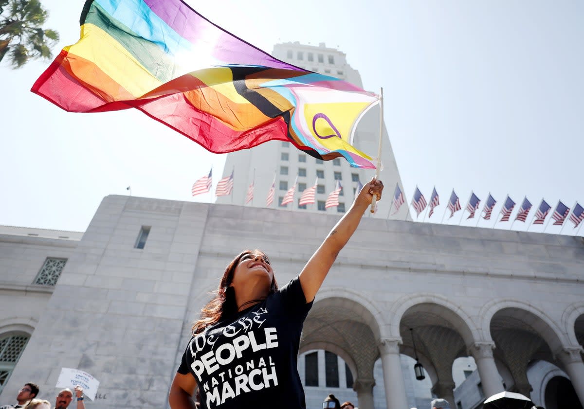 A protester waves a Pride flag incorporating the purple circle emblem of the intersex rights movement outside the Los Angeles city hall in July 2023 (Mario Tama/Getty Images)
