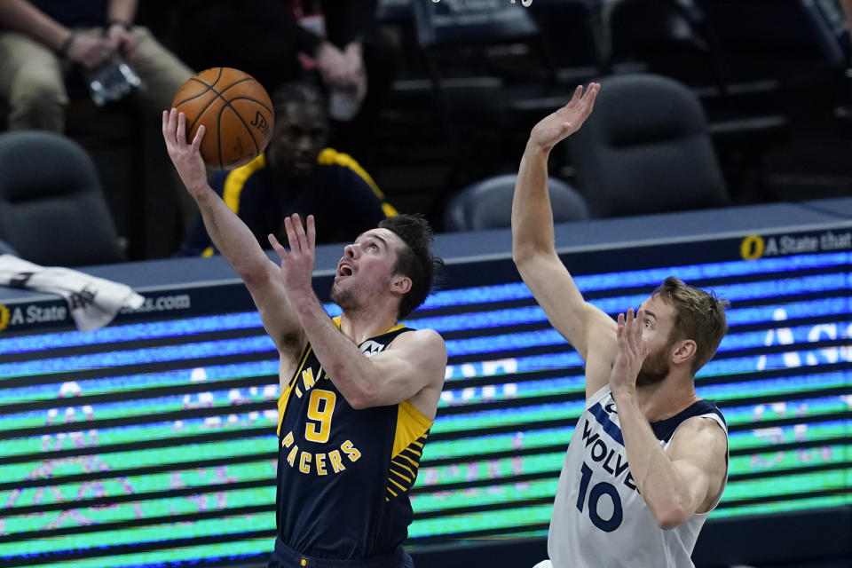 Indiana Pacers' T.J. McConnell (9) puts up a shot against Minnesota Timberwolves' Jake Layman (10) during the first half of an NBA basketball game, Wednesday, April 7, 2021, in Indianapolis. (AP Photo/Darron Cummings)