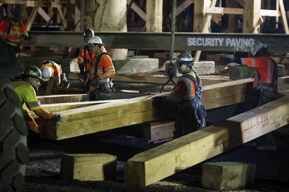 Construction crews shore up the fire-damaged 10 Freeway in Los Angeles on Thursday evening, Nov. 16, 2023. Gov. Gavin Newsom says the freeway will open next week earlier than estimated. (Sarah Reingewirtz/The Orange County Register via AP)