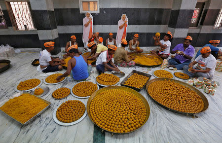 Sweets makers and supporters wearing caps of Bharatiya Janata Party (BJP) prepare "Laddu", a ball-shaped sweet, to be distributed among people to celebrate the swearing-in of Narendra Modi as India's Prime Minister, in Kolkata, India, May 30, 2019. REUTERS/Rupak De Chowdhuri