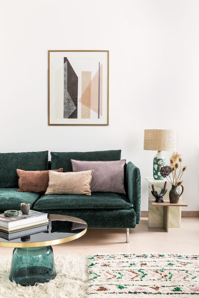 <p>Jeu de couleurs et de textures côté salon où l’architecte d’intérieur a bousculé le blanc en faisant retapisser son canapé Ikea d’un velours vert profond ( <a href="https://www.designersguild.com/fr/bienvenue-chez-designers-guild/l0" rel="nofollow noopener" target="_blank" data-ylk="slk:Designers Guild;elm:context_link;itc:0;sec:content-canvas" class="link ">Designers Guild</a>). En écho au sol en béton teinté comme de l’argile rose, un trio de coussins veloutés ( <a href="https://www.maisondevacances.com/" rel="nofollow noopener" target="_blank" data-ylk="slk:Maison de Vacances;elm:context_link;itc:0;sec:content-canvas" class="link ">Maison de Vacances</a>) jette un voile de poudre, subtilement décliné des tapis marocains au bout de canapé “Distinct” en pierre acrylique ( <a href="https://www.fleux.com/marques/ferm-living-paris" rel="nofollow noopener" target="_blank" data-ylk="slk:Ferm Living chez Fleux;elm:context_link;itc:0;sec:content-canvas" class="link ">Ferm Living chez Fleux</a>) en passant par l’œuvre sur papier de Kim Bartelt ( <a href="https://www.amelie-paris.com/fr/" rel="nofollow noopener" target="_blank" data-ylk="slk:Amélie Maison d’Art;elm:context_link;itc:0;sec:content-canvas" class="link ">Amélie Maison d’Art</a>). Lampe vintage en raphia et céramique, chandelier et pichet chinés. Tapis, l’un en peau de mouton et l’autre berbère en laine chinés au Maroc. Table basse « Bell » en verre et laiton de Sebastian Herkner ( <a href="https://www.classicon.com/" rel="nofollow noopener" target="_blank" data-ylk="slk:ClassiCon;elm:context_link;itc:0;sec:content-canvas" class="link ">ClassiCon</a>).</p><p> <br> <br> <br> </p><br>