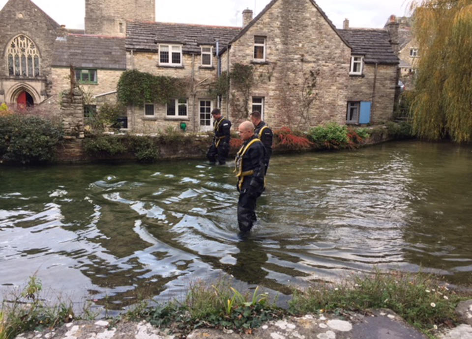 A police team searches a mill pond in Swanage (PA Images)