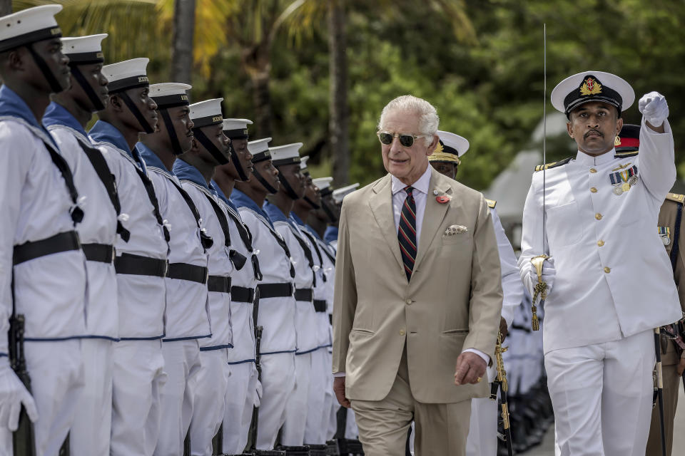 FILE - Britain's King Charles III, second from right, inspects the guard of honor on a visit to meet Royal Marines and Kenyan Marines at Mtongwe Naval Base, in Mombasa, Kenya on Nov. 2, 2023. While the monarchy is a symbol of Britain's history, that can be a two-edged sword. The crown is also a reminder of the British Empire's dominance of indigenous people around the world and its role in the trans-Atlantic slave trade. Charles faces pressure to address these issues from Prince Harry, who has called on the royal family to confront its unconscious racism. The king addressed the misdeeds of Britain's colonial history during a state visit to Kenya. (Luis Tato/Pool Photo via AP, File)