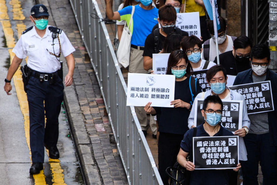 Pro-democracy protesters hold black placards that translate as 