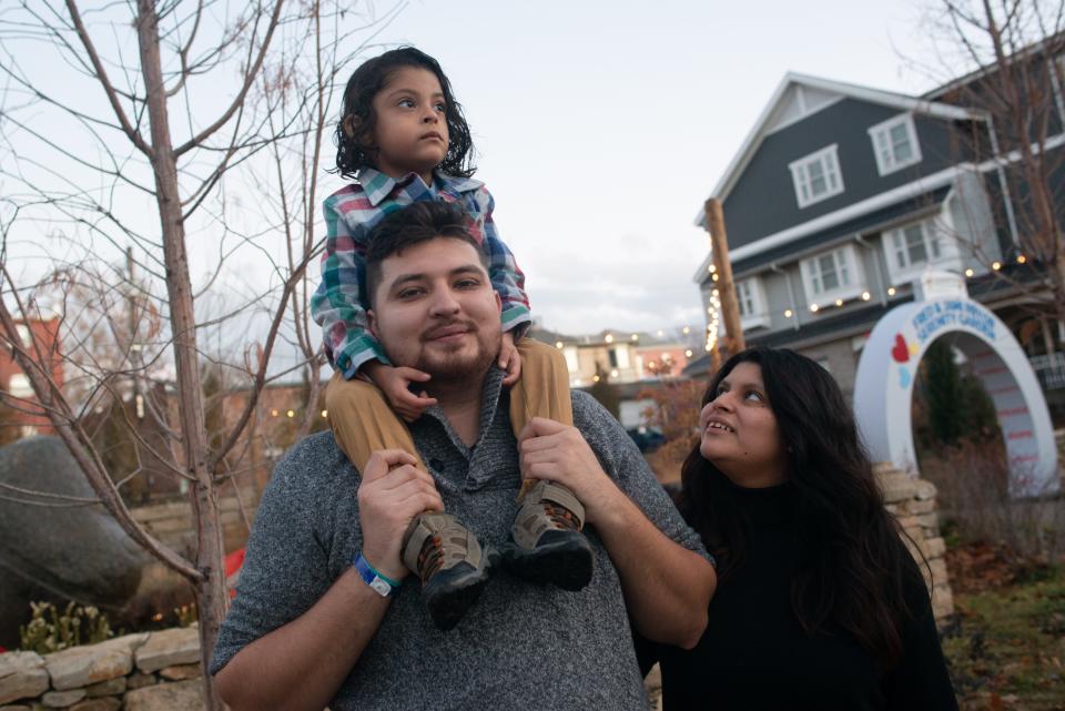 Four-year-old Antonio Meixueiro rides on the shoulders of his father, Isidro Meixueiro, as Antonio's mother and Isidro's wife, Abigail Quintero, looks on Tuesday at the serenity garden of a Ronald McDonald House in Kansas City, Mo.. The family has been living at the complex while their newest addition, Ellieana Meixueiro, remains in a hospital neonatal intensive care unit after being born prematurely.