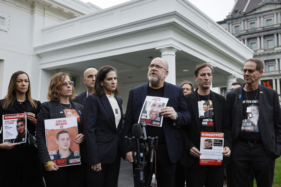 Family members of Americans who were taken hostage by Hamas during the Oct. 7 attacks in Israel hold photos of their loved ones and talk to reporters outside the White House. 