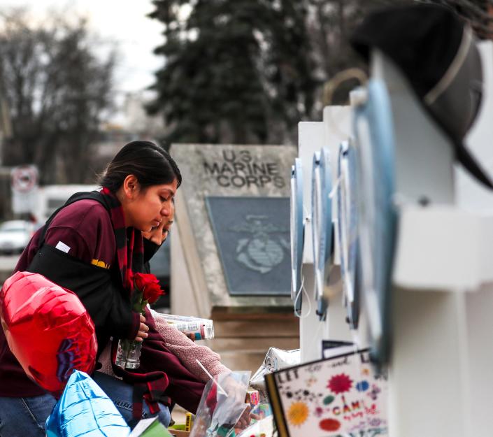 Sasha Catalan, left, and Rocio Castillo, right, place items at Veterans Memorial Park on Wednesday to remember those killed in the Waukesha Christmas Parade tragedy on Nov. 21.