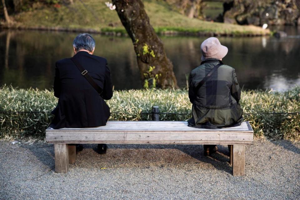An elderly man and woman sit on a bench in a park in Tokyo (AFP/Getty Images)