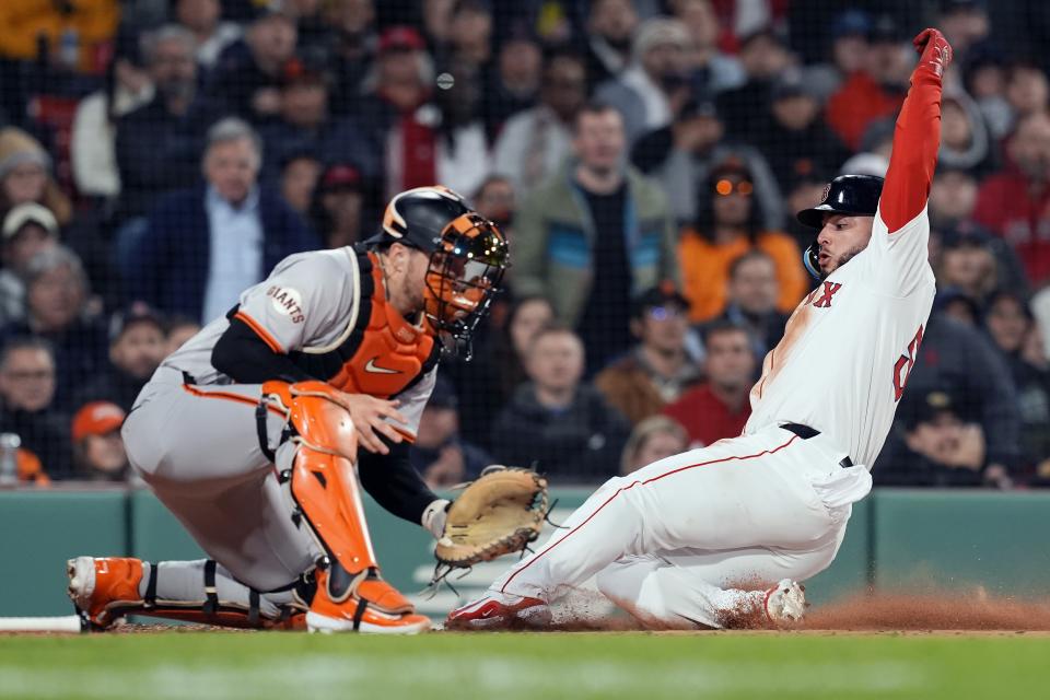 Boston Red Sox's Wilyer Abreu scores ahead of the throw to San Francisco Giants catcher Patrick Bailey on a single by Rob Refsnyder during the third inning of a baseball game, Tuesday, April 30, 2024, in Boston. (AP Photo/Michael Dwyer)