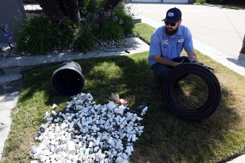 Calabasas, CA - June 07: Derek Krauss with the Las Virgenes Municipal Water District inspects a home switching from a sprinkler to drip system while surveying homes in the Mountain View Estates on Tuesday, June 7, 2022 in Calabasas, CA. The district's residents are under new water restrictions given the drought, and the Las Virgenes Municipal Water District -- which oversees water usage for affluent communities including Calabasas and Agoura Hills -- is tasked with making sure people are complying with the rules. (Dania Maxwell / Los Angeles Times)