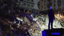 People try to reach trapped residents in a collapsed building in Diyarbakir, southeastern Turkey, early Monday, Feb. 6, 2023. A powerful earthquake has caused significant damage in southeast Turkey and Syria and many casualties are feared. Damage was reported across several Turkish provinces, and rescue teams were being sent from around the country.(AP Photo/Mahmut Bozarsan)