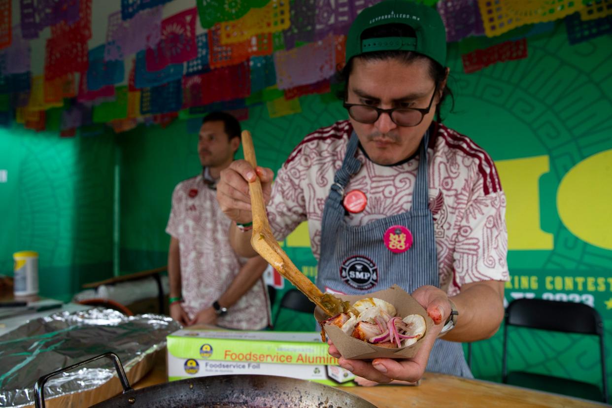 Arturo Gutierrez with Mexico BBQ Team drizzles the team’s “drunken salsa,” which gets its name from being cooked with beer, on a pork cheek taco in their booth before the start of the Memphis in May World Championship Barbecue Cooking Contest at Tom Lee Park in Downtown Memphis on Wednesday, May 17, 2023.