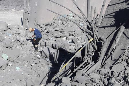 A man inspects the damage to collapsed buildings after what activists said was a U.S.-led air strike on Kafar Joum village in West Aleppo countryside November 6, 2014. REUTERS/Stringer