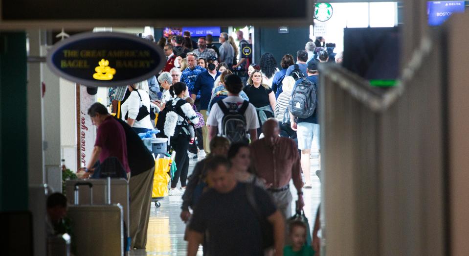 Travelers fill a concourse as they prepare to depart from Southwest Florida International Airport in Fort Myers on Friday, March 1, 2024.