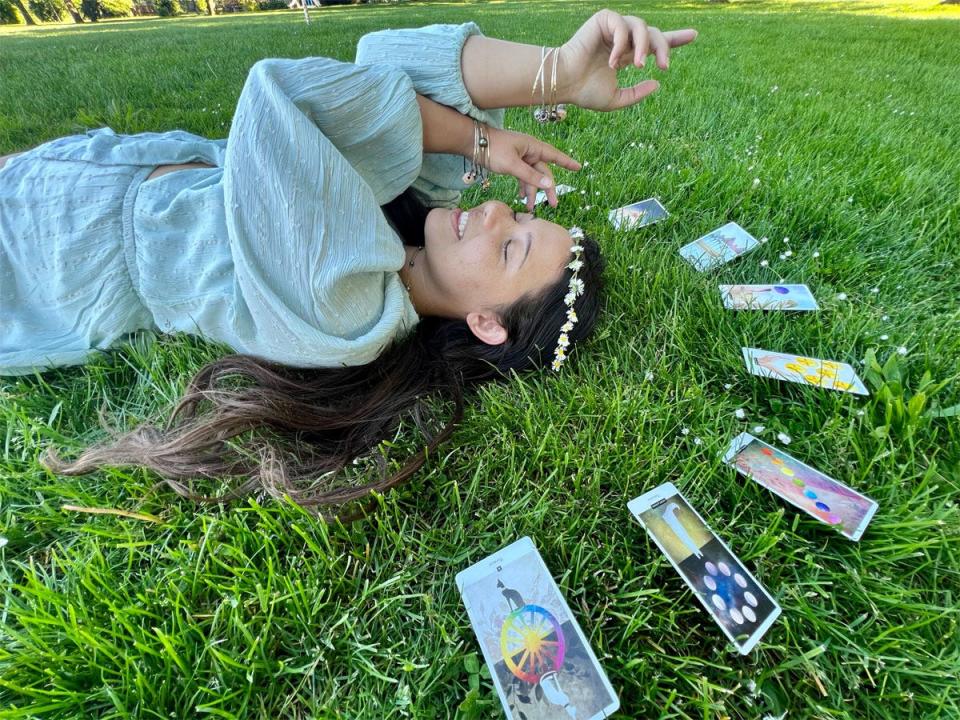 ashley probst laying in the grass surrounded by tarot cards