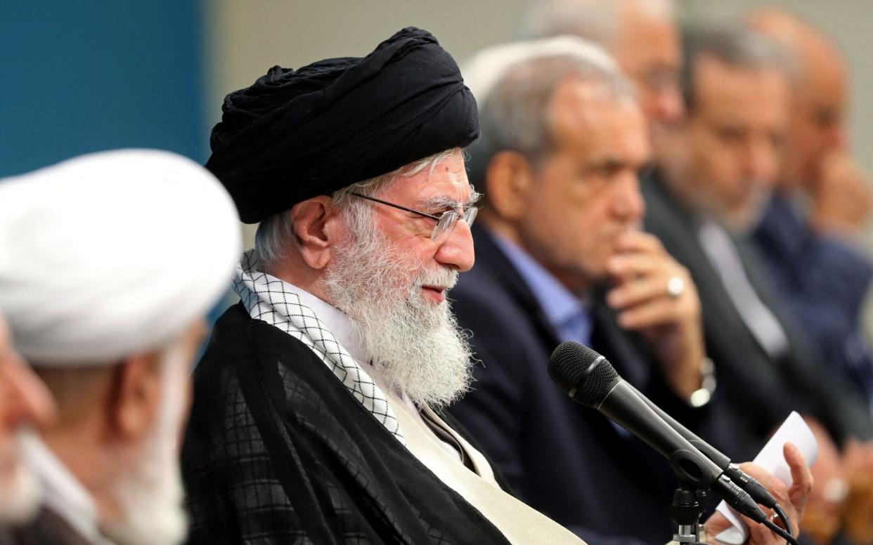 The Ayatollah wears clerical dress as he sits in conference with ministers