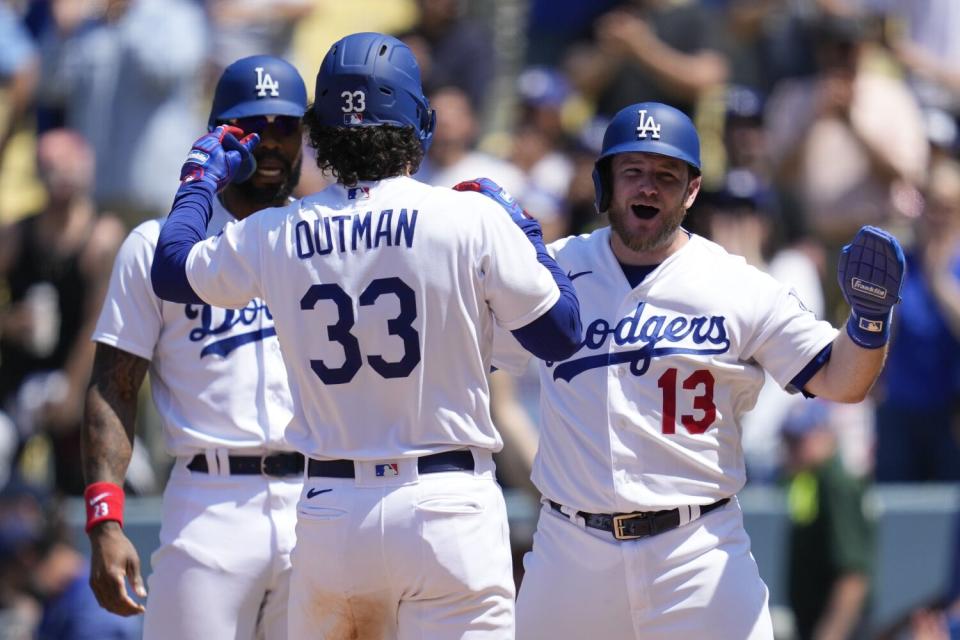 James Outman celebrates with teammates Jason Heyward and Max Muncy.