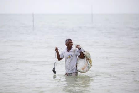 Hong Klathalay walks towards his fishing boat in Khao Lak, Phang Nga province December 14, 2014. REUTERS/Damir Sagolj