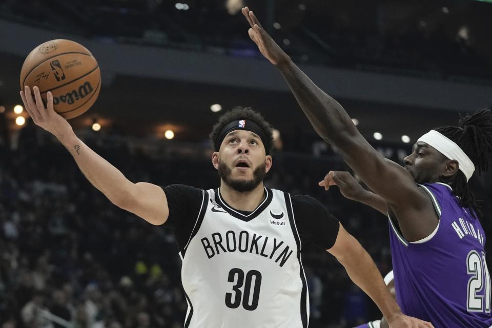 Brooklyn Nets' Seth Curry shoots past Milwaukee Bucks' Jrue Holiday during the first half of an NBA basketball game Thursday, March 9, 2023, in Milwaukee. (AP Photo/Morry Gash)