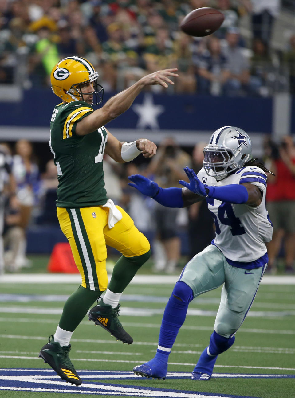 Green Bay Packers quarterback Aaron Rodgers, left, throws a pass as Dallas Cowboys middle linebacker Jaylon Smith (54) defends in the first half of an NFL football game in Arlington, Texas, Sunday, Oct. 6, 2019. (AP Photo/Ron Jenkins)