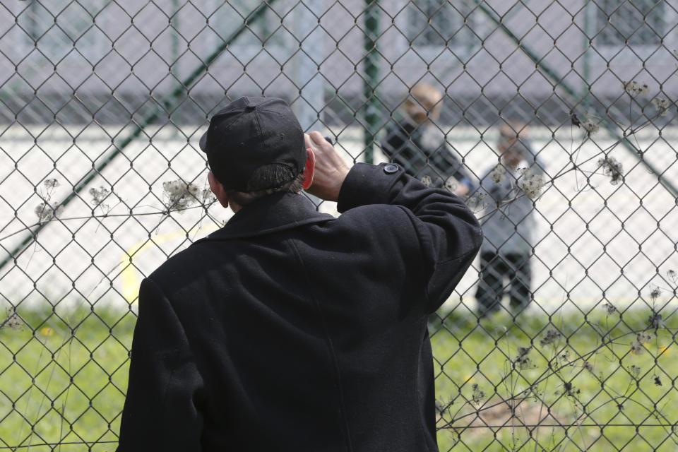 Hajdar Selimovic calls to his nephew Ismail behind a fence at a detention center where authorities have brought back from Syria 110 Kosovar citizens, mostly women and children in the village of Vranidol on Sunday, April 20, 2019. Four suspected fighters have been arrested, but other returnees will be cared for, before being sent to homes over the coming days, according to Justice Minister Abelard Tahiri.(AP Photo/Visar Kryeziu)