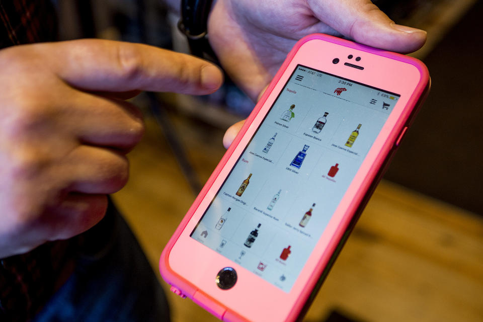 PORTLAND, ME - APRIL 14: Kevin Casey, manager of Old Port Spirits & Cigars, demonstrates the app Drizly that his store is partnering with to deliver liquor in the Portland area starting Thursday, April 14, 2016. (Photo by Gabe Souza/Portland Portland Press Herald via Getty Images)