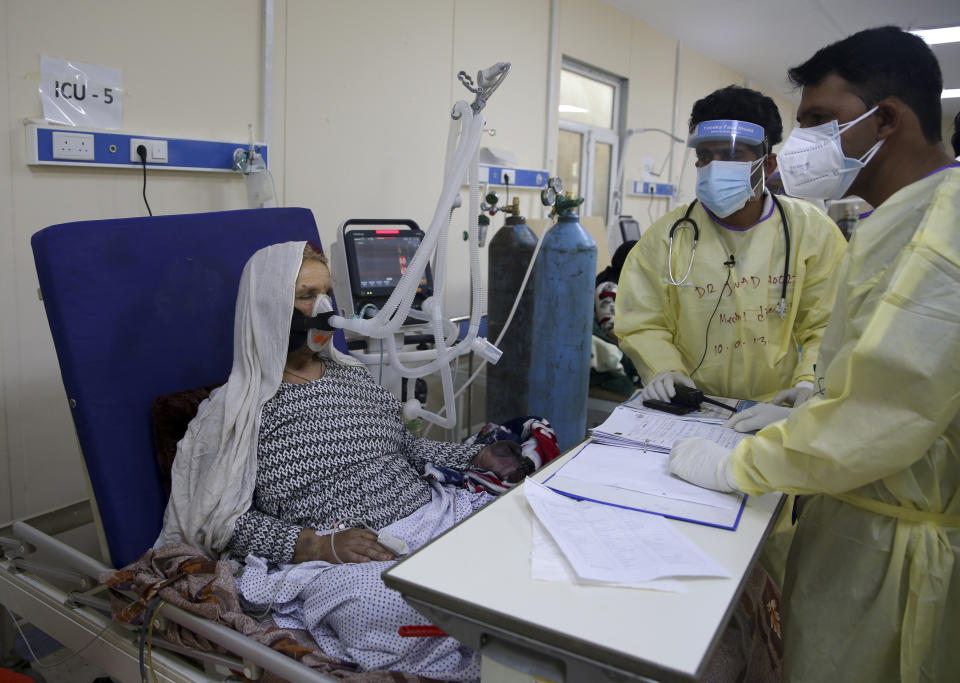 Afghan doctors help a patient to breathe through an oxygen mask in the Intensive Care Unit ward for COVID-19 patients at the Afghan-Japan Communicable Disease Hospital in Kabul, Afghanistan, Tuesday June 30, 2020. (AP Photo/Rahmat Gul)