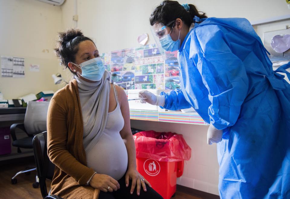 A nurse gives a shot of the Pfizer vaccine for COVID-19 to a pregnant woman in Montevideo, Uruguay, Wednesday, June 9, 2021. (AP Photo/Matilde Campodonico)