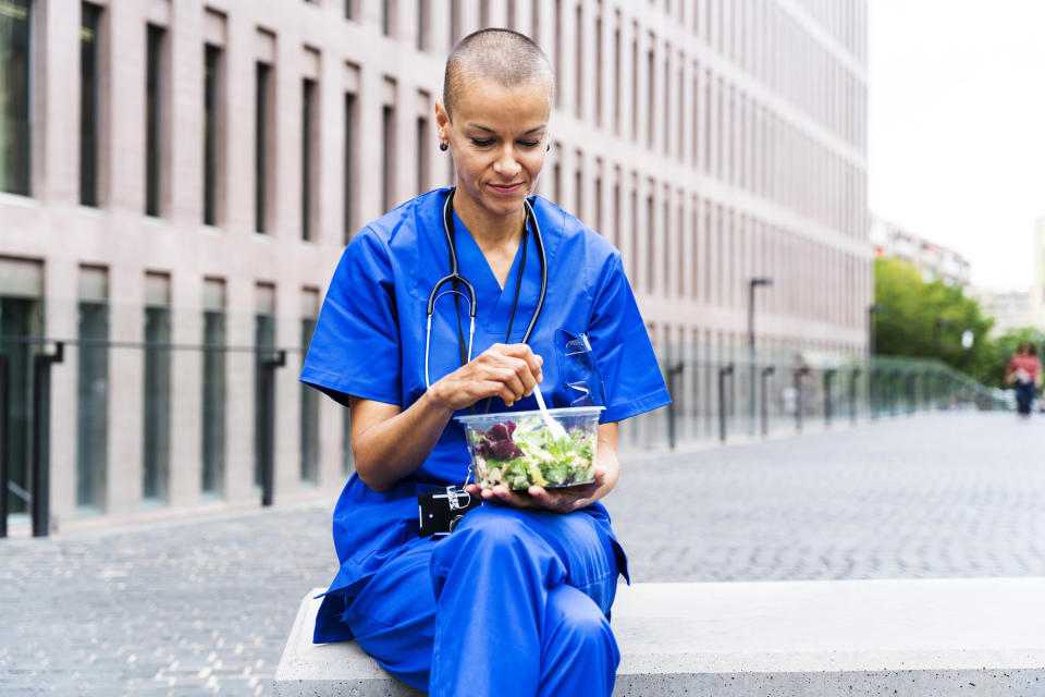 nurse eating a salad outside of the hospital