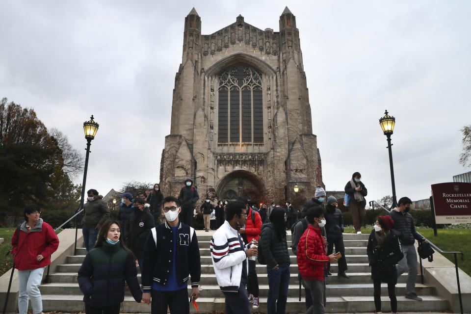 Mourners leave Rockefeller Memorial Chapel in Chicago after attending a memorial service for Shaoxiong "Dennis" Zheng on Thursday, Nov. 18, 2021. Zheng, a graduate of the University of Chicago, was shot and killed in a robbery. (Terrence Antonio James/Chicago Tribune via AP)