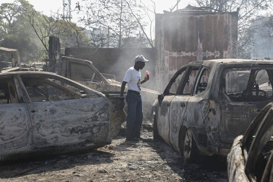 A man looks for salvageable items at a car mechanic shop that was set fire during gang violence in Port-au-Prince, Haiti, Monday, March 25, 2024. (AP Photo/Odelyn Joseph)