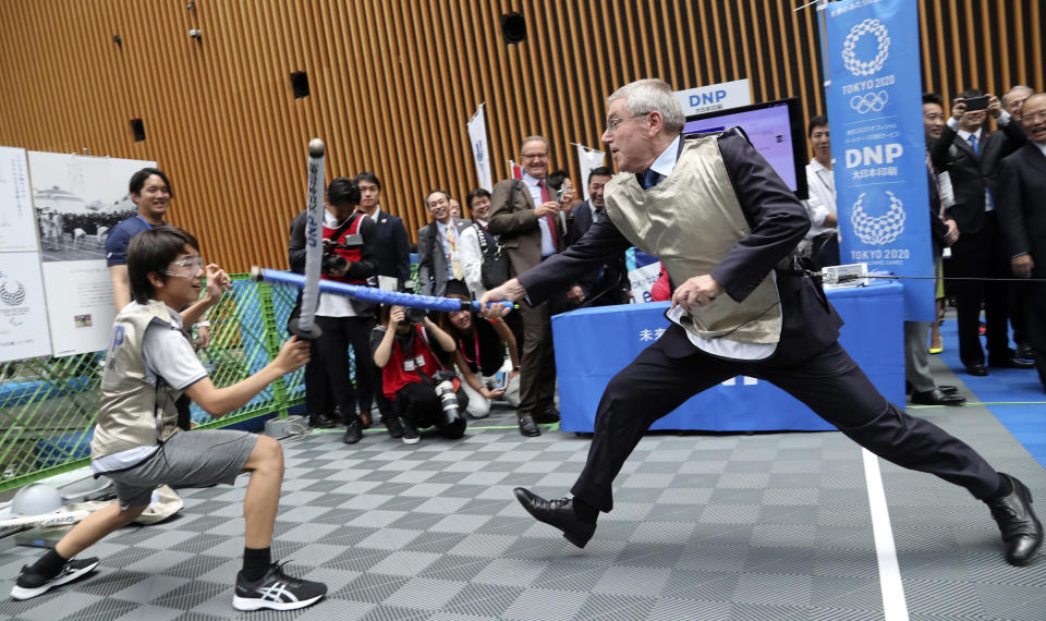 IOC President Thomas Bach, right, performs mock fencing with Japanese junior high school student Yui Hashimoto during a Olympic Games Tokyo 2020 One year to Go ceremony event in Tokyo, Wednesday, July 24, 2019. Bach is a former Olympic fencer and won a team gold medal at the 1976 Montreal Games. Fans, sponsors and politicians celebrated the day around the Japanese capital, displaying placards and clocks showing 365 days to go until the opening ceremony on July 24, 2020. (AP Photo/Koji Sasahara, Pool)