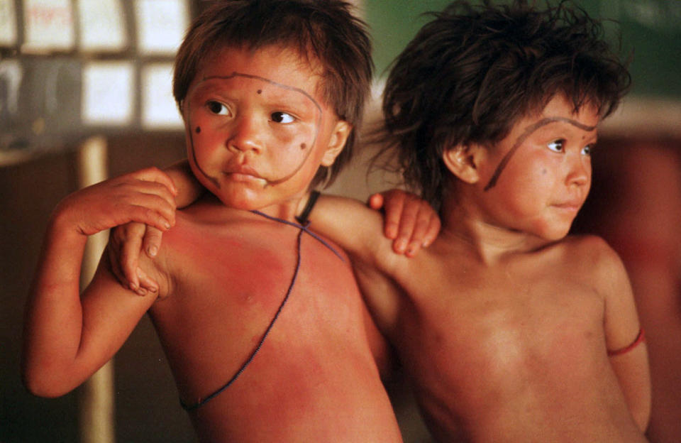 FILE - In this March 22, 1998 file photo, Yanomami children stand arm in arm in the village of Demini in the Amazon jungle, Brazil. On Monday, May 24, 2021, a Supreme Court justice ordered the government to protect Indigenous populations, including the Yanomami, threatened in recent weeks by illegal miners who appear to have been emboldened by support for their industry from President Jair Bolsonaro. (AP Photo/Dario Lopez-Mills, File)