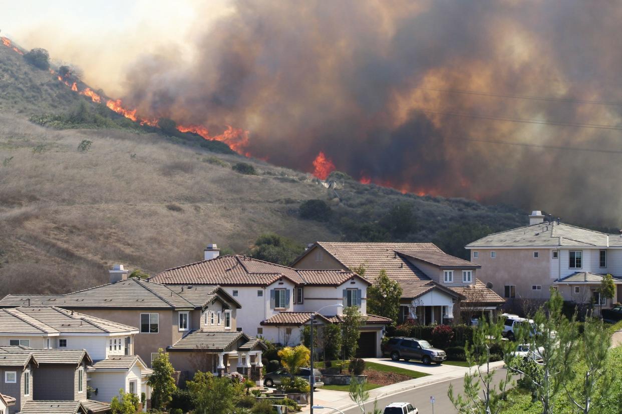 Southern California brush fire near houses.