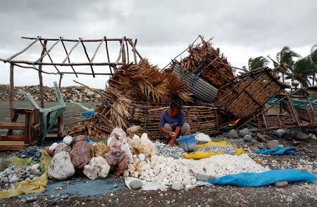 A woman sorts decorative rocks outside her shop toppled during Typhoon Haima, in Pasuiquin, Ilocos Norte in northern Philippines, October 20, 2016. REUTERS/Erik De Castro