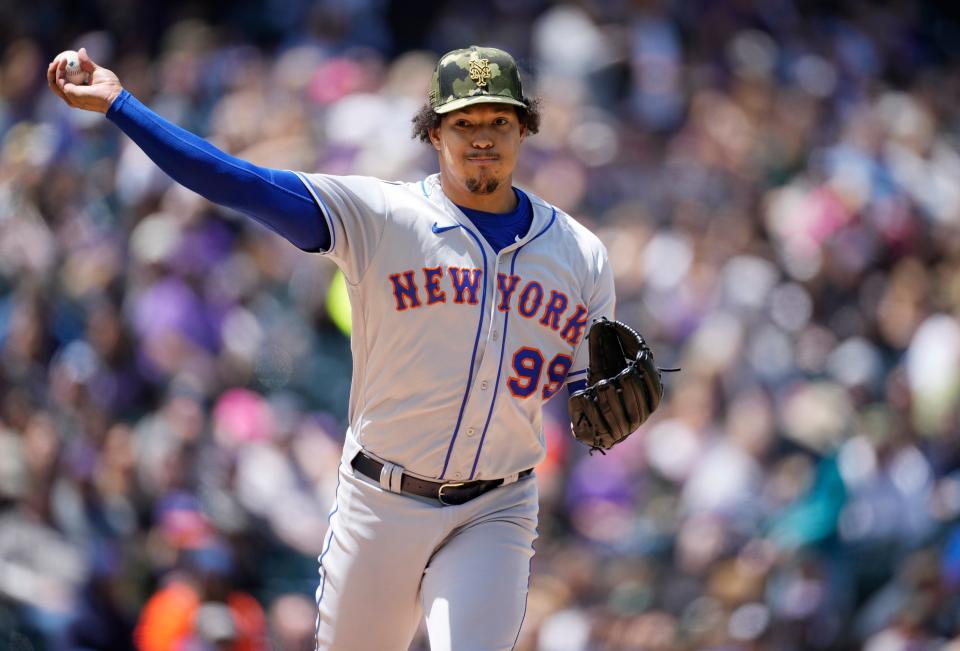 New York Mets starting pitcher Taijuan Walker turns to make a pickoff-attempt against Colorado Rockies' Yonathan Daza in the first inning of a baseball game Sunday, May 22 2022, in Denver.