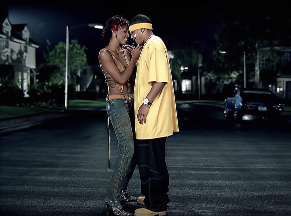 Kelly Rowland and Nelly stand together on street, cuddling