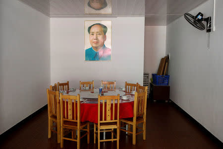 A portait of former Chinese leader Mao Zedong hangs above a dining table in a restaurant next to the Red Culture Training Centre in the mountains outside Jinggangshan, Jiangxi province, China, September 14, 2017. REUTERS/Thomas Peter