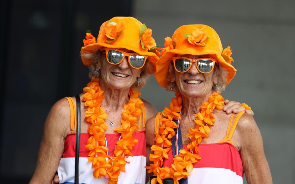 Netherlands fans pose outside the stadium before the match - Reuters