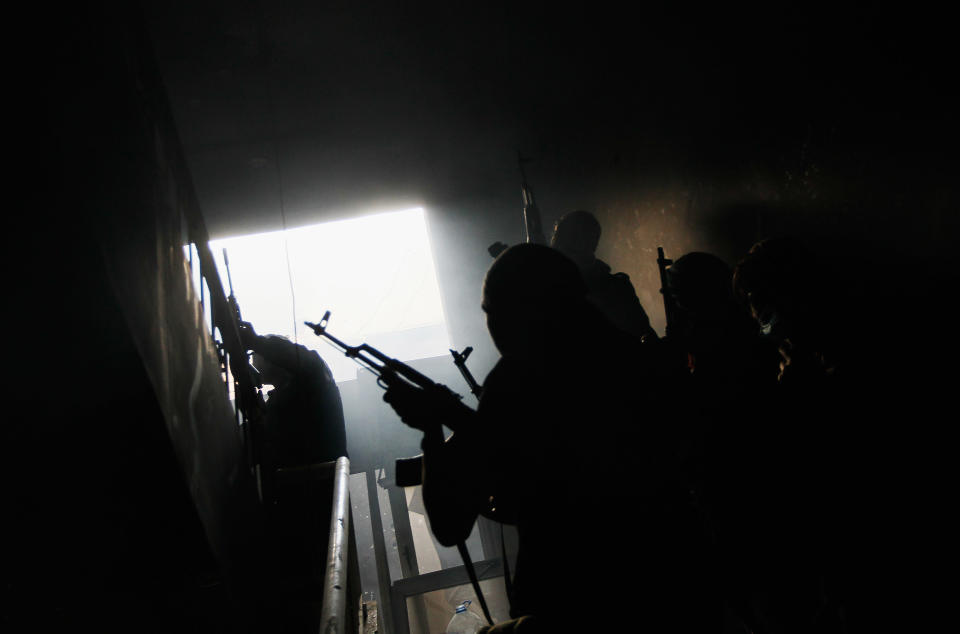 <p>Rebel fighters carefully move up a stairway in a building where they had trapped government loyalist troops during street fighting on Tripoli Street in downtown Misrata April 20, 2011 in Misrata, Libya. (Photo by Chris Hondros/Getty Images) </p>