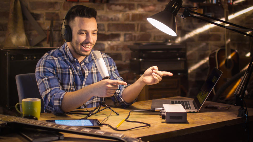 Young man makes a podcast audio recording at home in a garage.