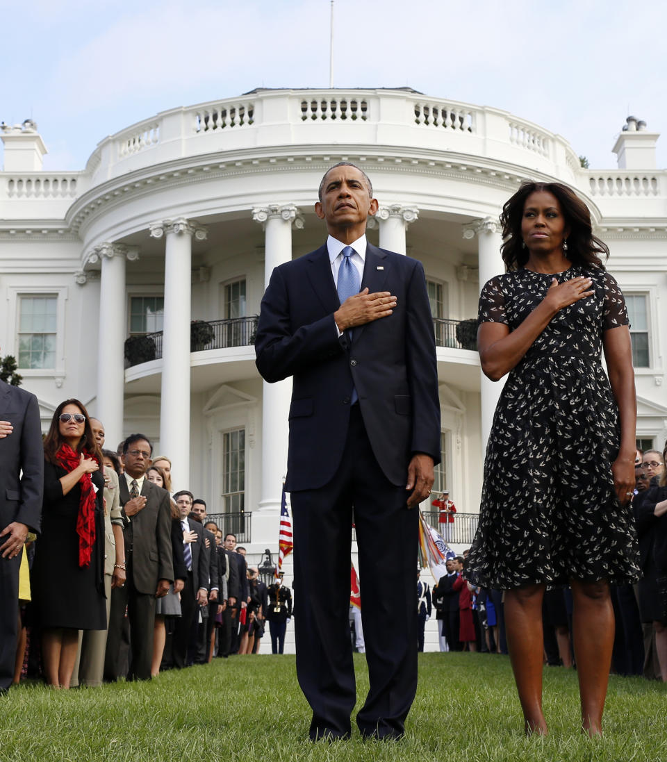 President Barack Obama and first lady Michelle Obama stand during the playing of Taps on the South Lawn of the White House in Washington, Thursday, Sept. 11, 2014, as they observe a moment of silence to mark the 13th anniversary of the 9/11 attacks. (AP Photo/Charles Dharapak)