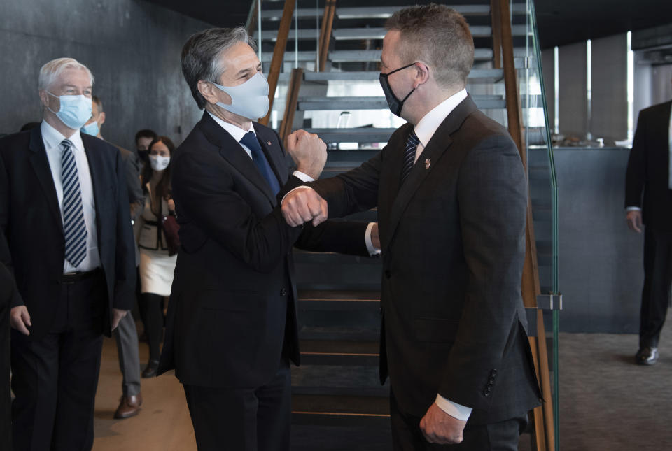 Icelandic Foreign Minister Gudlaugur Thor Thordarson, centre right, greets US Secretary of State Antony Blinken centre left, as he arrives for meetings at the Harpa Concert Hall in Reykjavik, Iceland, Tuesday, May 18, 2021. Blinken is touting the Biden administration's abrupt shift in its predecessor's climate policies as he visits Iceland for talks with senior officials from the world's Arctic nations. (Saul Loeb/Pool Photo via AP)