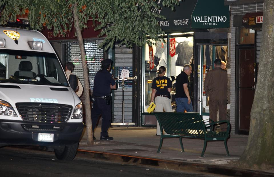 In this early Saturday, July 7, 2012 photo, authorities investigate the crime scene where clothing store owner Mohamed Gebeli was killed inside Valentino Fashion in the Bay Ridge neighborhood in the Brooklyn borough of New York. The same gun that killed Gebeli was also used in the murders of two other shopkeepers, according to police, with the latest victim being fatally shot Friday, Nov. 16, 2012, in Brooklyn's Flatbush neighborhood. (AP Photo/David Boe)