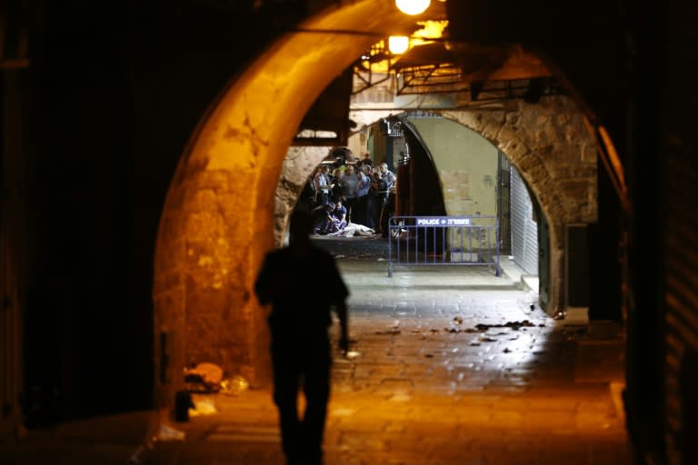 Israeli security forces and emergency services stand next to the body of a Palestinian who carried out a stabbing attack in the old city of Jerusalem on October 3, 2015