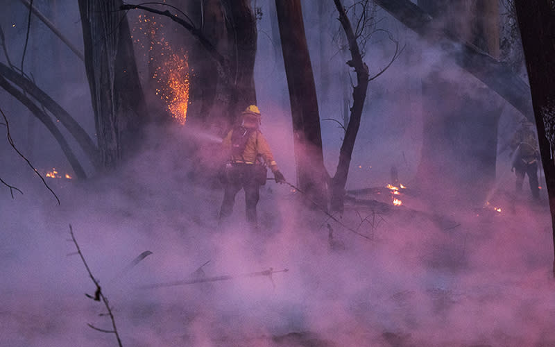 Firefighters work against a wildfire near Aromas, Calif.