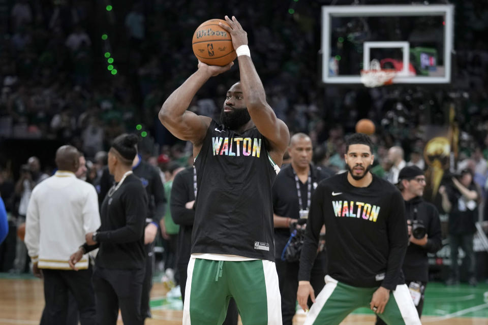 Boston Celtics guard Jaylen Brown, center, and forward Jayson Tatum, right, warm up while wearing shirts honoring basketball great Bill Walton ,before Game 1 of the the basketball team's NBA Finals against the Dallas Mavericks, Thursday, June 6, 2024, in Boston. (AP Photo/Charles Krupa)