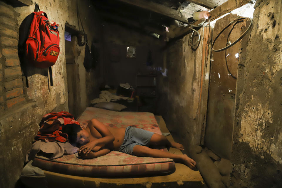 Cesar Velasquez, 14, lies on a mattress, while spending time with his cell phone, at his grandmother's house where he now lives, because his parents were detained during the government's crackdown on its war against drugs, in Santa Ana, El Salvador, Wednesday, Jan. 31, 2024. The crackdown has broad support among Salvadorans who have been able to retake their neighborhoods, but children left without parents have been among its heaviest costs. (AP Photo/Salvador Melendez)